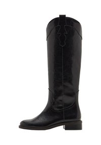 Bota de cuero negra hasta la rodilla con un acabado texturizado, que presenta un diseño recortado en la parte superior y un tacón bajo apilado. Superficie lisa con costuras decorativas.