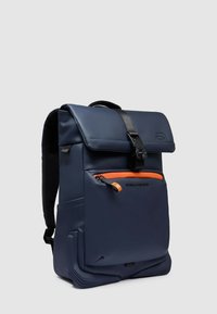 Sac à dos imperméable bleu marine avec fermeture à enroulement, poche frontale zippée orange, bretelles réglables et accents texturés à la base.
