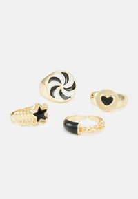 Conjunto de quatro anéis em metal com tom de ouro. Inclui um design em espiral, uma estrela preta, um contorno de coração e um estilo de corrente com um acento preto.