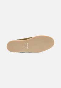 Suela de zapato de ante marrón con una superficie texturada, que presenta una suela exterior de color marrón claro y el nombre de la marca "Scarosso" en relieve con la talla 42.
