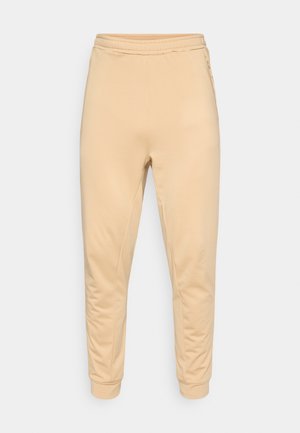 Pantaloni sportivi beige con vita elastica, polsini stondati e tasche laterali. Il tessuto è liscio con una leggera elasticità.