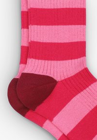 Medias a rayas con franjas alternas en rosa fuerte y rosa claro, con talón y punta en rosa oscuro. Textura de punto, longitud hasta la mitad de la pantorrilla.