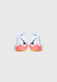 White athletic shoes with pink and yellow accents. Features a textured mesh upper, cushioned heel, and black logo details on the sides.