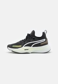 Černá atletická bota s síťovaným svrškem, bílými a zelenými akcenty, silnou mezipodešví a zadním poutkem. Vyznačuje se elegantním, moderním designem.