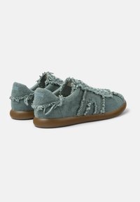Textilsneaker in gedämpftem Blaugrün mit ausgefransten Kanten. Verfügt über eine weiche Sohle und ein strukturiertes Material, das für Komfort und Atmungsaktivität sorgt.