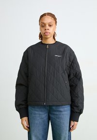 Crna quiltana bomber jakna s prednjim patentnim zatvaračem, rebrastim manžetama i Carhartt logom na lijevoj strani prsnog koša. Ima ležeran kroj i glatku teksturu.