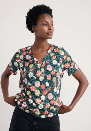 Haut à manches courtes floral avec un col en V en vert, arborant un motif coloré de différentes fleurs et feuilles. Fabriqué en tissu léger.