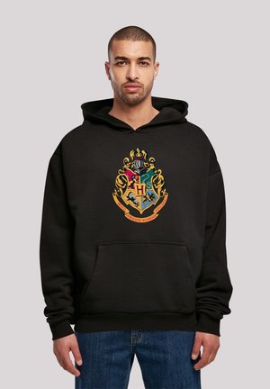 Black hoodie made of cotton with a front pocket. Features a colorful Hogwarts crest design on the chest. Relaxed fit, long sleeves.