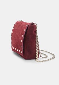 Borsa a tracolla in camoscio borgogna con chiusura a patta, dettagli con borchie in argento e una lunga tracolla in metallo. Forma rettangolare con superficie texturizzata.