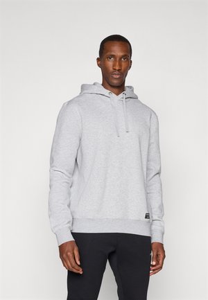 Gray sweatshirt with a hood, long sleeves, and textured fabric. Features a kangaroo pocket and ribbed cuffs, paired with dark pants.