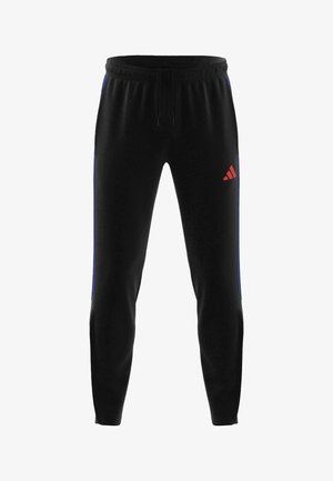 Schwarze Sporthose mit elastischem Bund, Kordelzug, schmal zulaufenden Beinen, blauen Seitenstreifen und kleinem roten Adidas-Logo am rechten Oberschenkel.