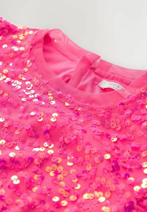 Różowy top z cekinami, ozdobiony okrągłymi, błyszczącymi cekinami na siateczkowej tkaninie, z okrągłym dekoltem i zapięciem na guziki z tyłu. Etykieta widoczna od wewnątrz.