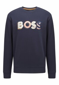 Sweatshirt bleu marine avec des lettres 3D colorées et audacieuses épelant "BOSS" sur la poitrine, comportant des manches longues et un col rond.