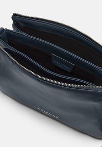 Borsetta in pelle blu navy con cerniera e molteplici scomparti, che mostra la fodera interna e un'etichetta del marchio all'interno.