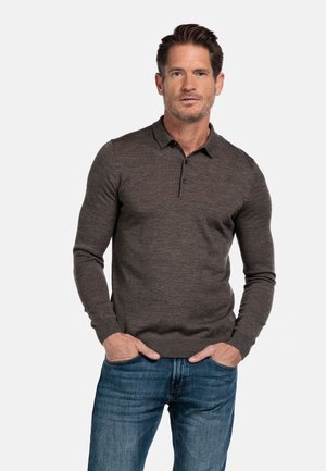Bruine lange mouwen polo met een button-down kraag, geribbelde manchetten en een getailleerd ontwerp, gecombineerd met blauwe spijkerbroek.