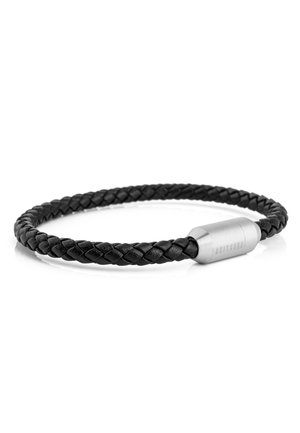 Bracelet en cuir noir tressé avec fermoir magnétique cylindrique argenté gravé de texte sur fond blanc.