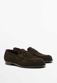 Mørkebrune ruskindsloafers med moccasin-design, der har en syet accent og en lavprofileret lædersål.