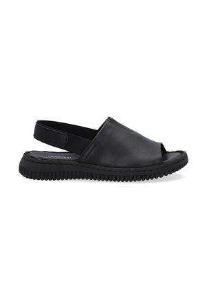 Sandales noires en cuir à talon nu, avec une ouverture à l'avant, une semelle en caoutchouc texturé et un design minimaliste avec une finition lisse.