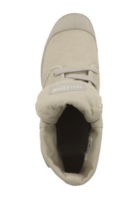 Beige kangaskankaiset korkeat tossut, joissa on pyöreä kumikärki, litteät nauhat ja pehmustettu nilkkasauma; logo näkyy kielekkeellä.