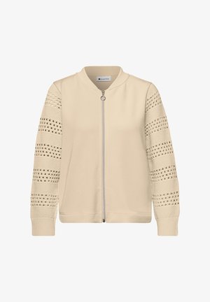 Veste beige à fermeture éclair avec manches en maille texturée présentant des rayures ajourées et des poignets et col côtelés.