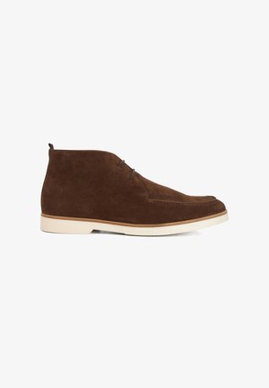 Brown suede ankle boots with a cream rubber sole, featuring two eyelet lacing, a smooth finish, and a rounded toe design.