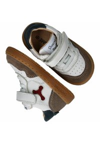 Witte en grijze leren schoenen met een grijze suède accent, rode hardwaredetails, klittenbandsluiting en een gestructureerde gumrubberen zool.