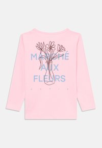 Garās piedurkņu rozā krekls ar melnu zīmējumu, kurā ir ziedi vāzē, zem kura ir zils uzraksts "MARCHE AUX FLEURS PARIS".