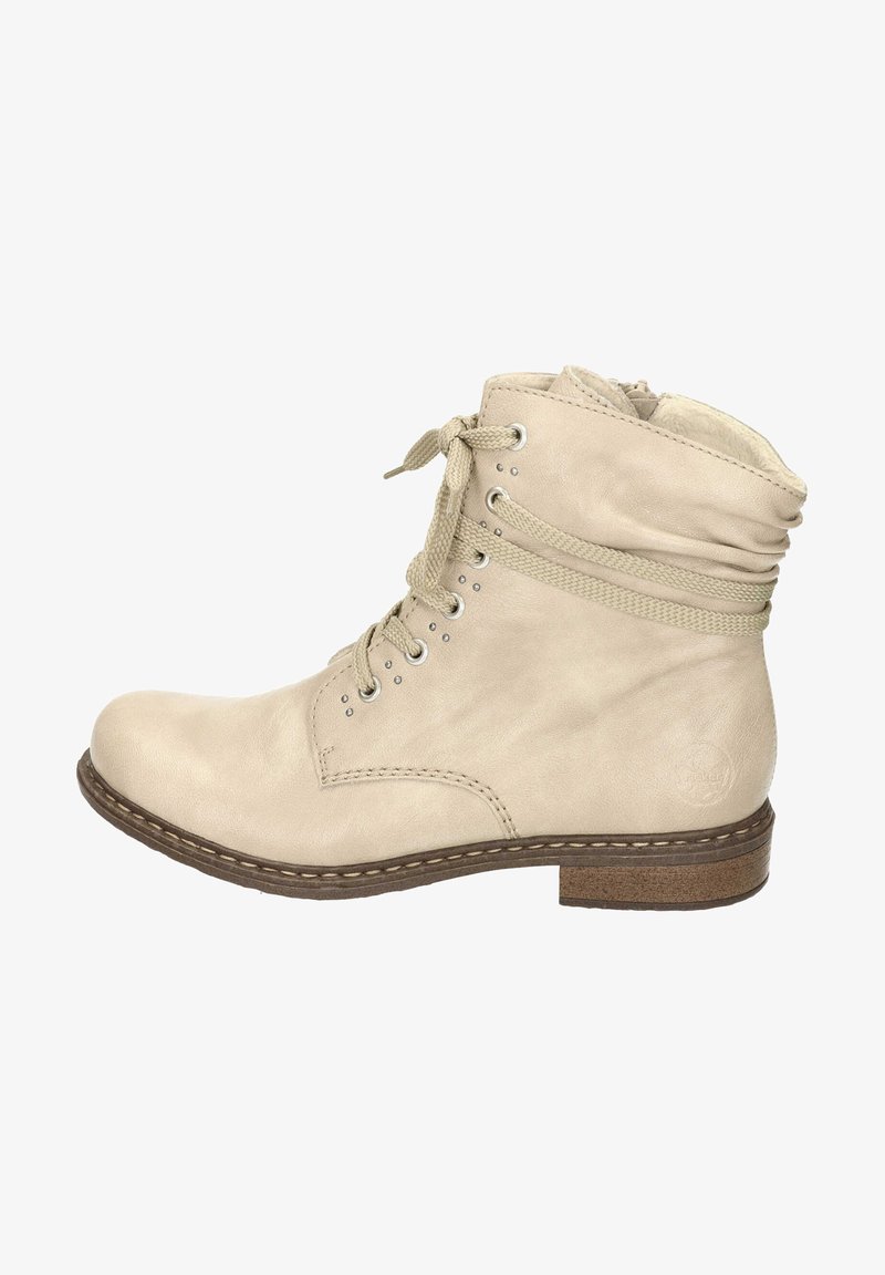 Beige leren enkellaars met vetersluiting, ronde neus en gevoerd kraagje. Gestikte details en rubberachtige zool voor grip.