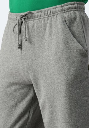 Pantaloni sportivi grigi realizzati in tessuto morbido, dotati di una cintura elasticizzata con cordino, tasche laterali e una texture liscia.