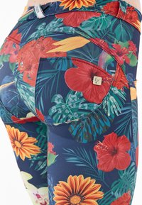 Leggings aderenti in tessuto blu navy con un vivace motivo floreale caratterizzato da hibiscus rossi e accenti di girasoli gialli. Include tasche posteriori.