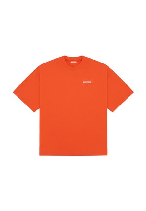 T-shirt orange vif à manches courtes avec col rond et petit texte blanc "WRSTBHVR" sur la poitrine gauche et à l'intérieur du col.