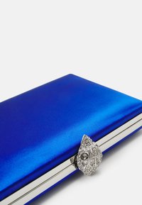 Kungsblå satinclutch med en metallisk silverram och ett dekorativt lås med rhinstenar och en mörk ädelsten.