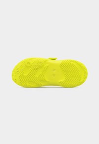 Φωτεινή κίτρινη σόλα αθλητικού παπουτσιού με ζιγκ-ζαγκ και κυκλικά σχέδια πέλματος, μέγεθος W7, σε απλό λευκό φόντο.