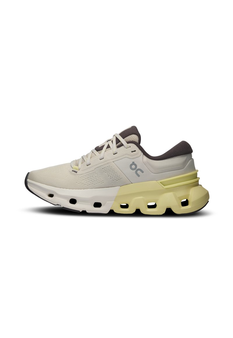 Chaussure de course légère en crème et jaune pâle, avec une tige texturée, un col rembourré et une semelle extérieure segmentée distinctive.