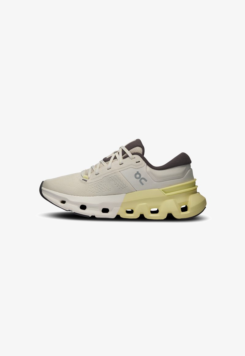 Chaussure de course légère en crème et jaune pâle, avec une tige texturée, un col rembourré et une semelle extérieure segmentée distinctive.