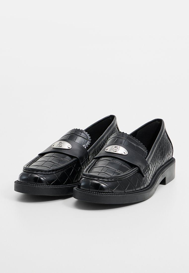 Schwarze Slipper mit strukturiertem Krokodil-Muster, Obermaterial aus Leder, Riemen mit silbernem Akzent und niedriger Blockabsatz.