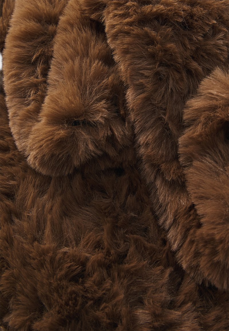 Prim-plan cu un material de blană falsă, moale și densă, de culoare maronie, cu o textură bogată și variații naturale în nuanțe și pufoșenie.