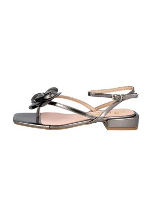 Sandalia metálica gris con tacón cuadrado, que presenta un acento decorativo de flor, correas delgadas y un seguro hebilla en el tobillo. Textura suave.