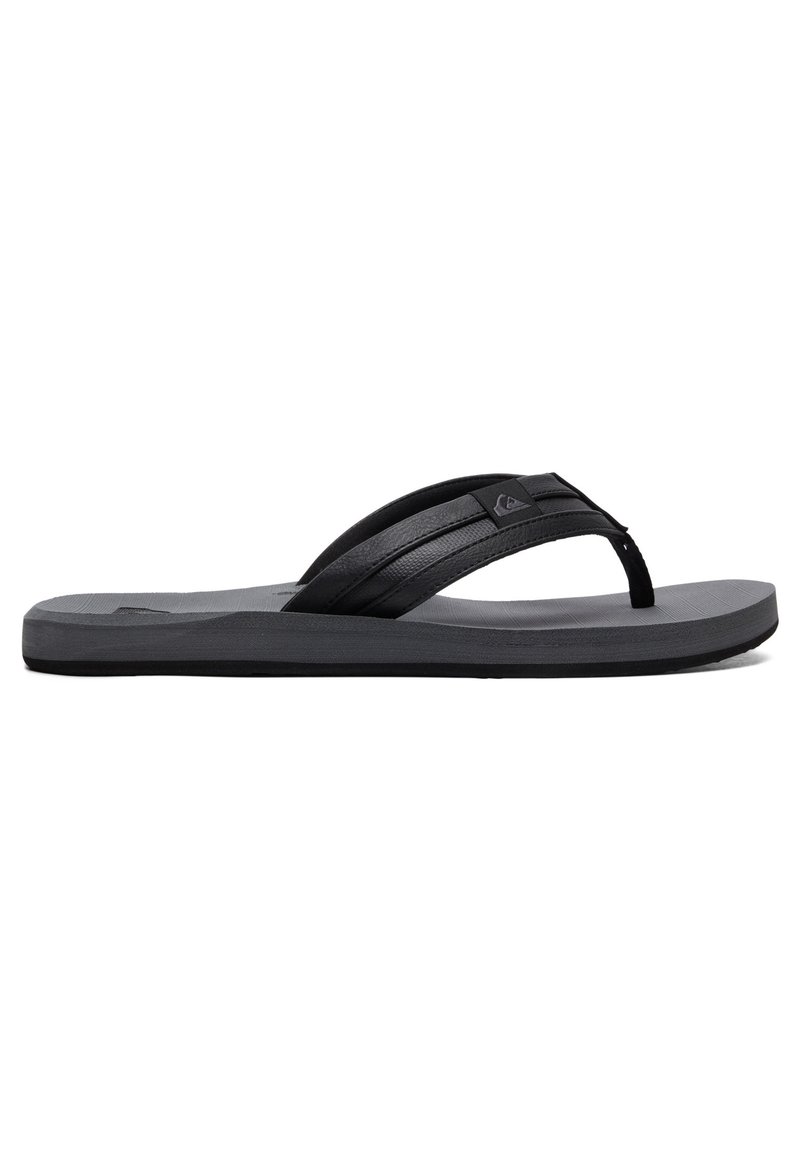 Flip-flop negru cu o talpă din cauciuc moale, având două bretele texturate, un detaliu pronunțat cu logo și o talpă netedă, plată.