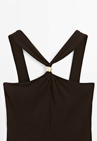 Black sleeveless top with wide straps crossed at back, gathered at center with a small gold rectangular clasp.