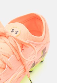 Calzature corallo vivace con tessuto texturizzato, lacci e dettagli del logo circolare. Presentano un design leggero e una leggera sfumatura verso il giallo sulle suole.