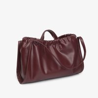 Sac en cuir bourgogne profond avec un dessus froncé, une courte poignée et une longue sangle réglable sur fond blanc.