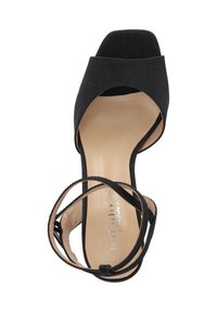 Scarpa con tacco alto nera, open-toe, con tomaia in tessuto morbido, cinturino alla caviglia e soletta beige con logo. Suola piatta con texture minima.