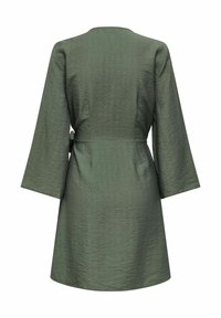 Robe vert olive texturée, longueur genou, avec des manches longues et larges ainsi qu'une ceinture nouée sur le côté, vue de dos sur un fond blanc.