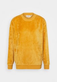 Sweatshirt giallo in velluto con scollatura rotonda e polsini a costine. Presenta una vestibilità leggermente ampia e una texture sottile. Logo del marchio sul polsino.