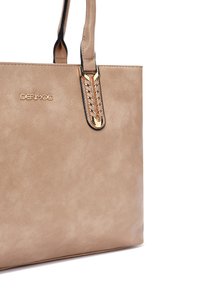 Borsa tote in finta pelle beige dal design elegante, con un accento dorato e cuciture intricate sulla maniglia. Logo visibile sul davanti.