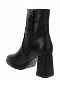 Stivaletto in pelle nera con tacco a blocco, chiusura con zip laterale, superficie liscia e punta leggermente affusolata.