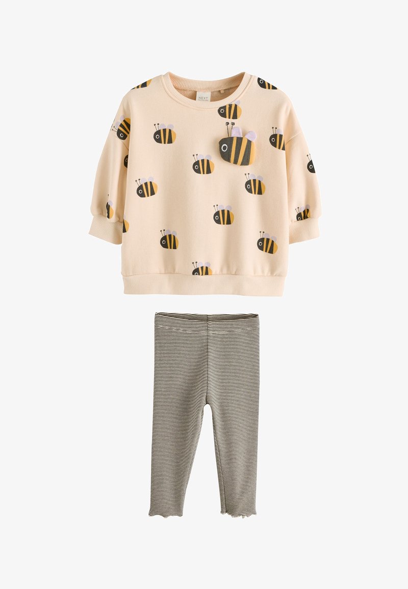 Haut à manches longues crème avec imprimés d'abeilles noires et jaunes, et leggings rayés noir et blanc pour tout-petits ou jeunes enfants.