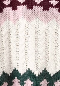 Pull en tricot avec un motif en zigzag dans des tons de bourgogne, rose, blanc et vert, avec des torsades texturées et une maille épaisse.
