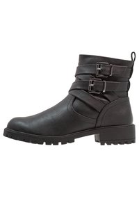 Botas negras de tobillo con un acabado de cuero liso, que cuentan con tres hebillas decorativas, suela de goma resistente y un diseño de punta redonda.